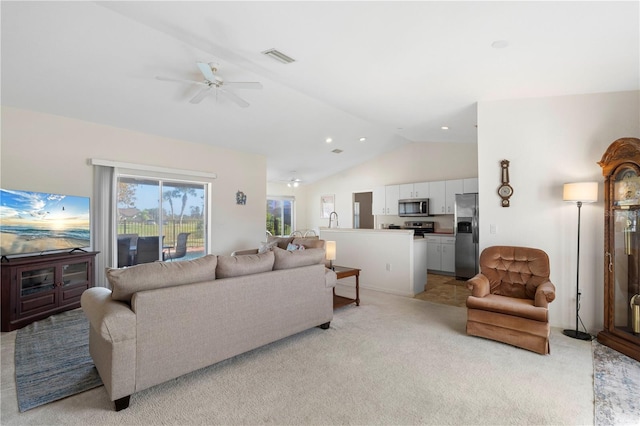 carpeted living room with lofted ceiling and ceiling fan