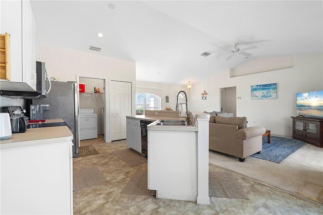 kitchen featuring washer / dryer, lofted ceiling, white cabinets, a kitchen island with sink, and sink