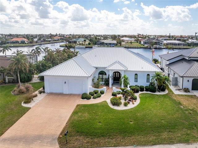 1945 Jamaica Way, Punta Gorda, FL 33950 - single story home with decorative driveway, an attached garage, a metal roof, a water view, and a residential view