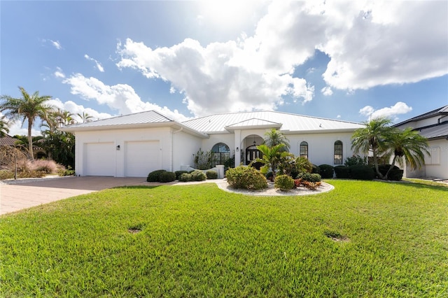 1945 Jamaica Way, Punta Gorda, FL 33950 - mediterranean / spanish home featuring driveway, an attached garage, a standing seam roof, a front lawn, and stucco siding