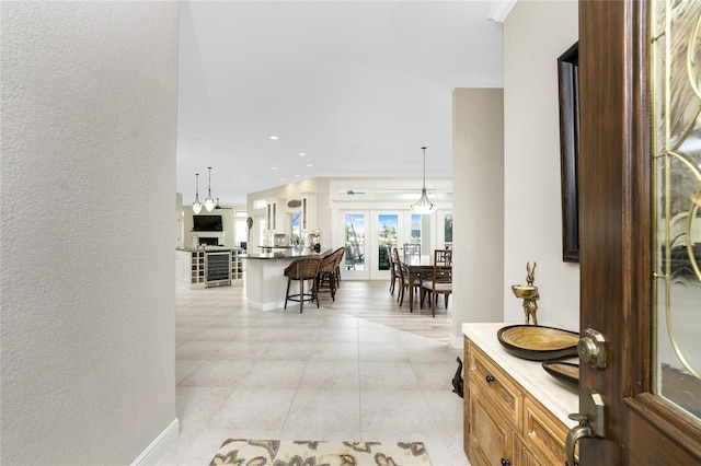 corridor with light tile patterned floors and crown molding