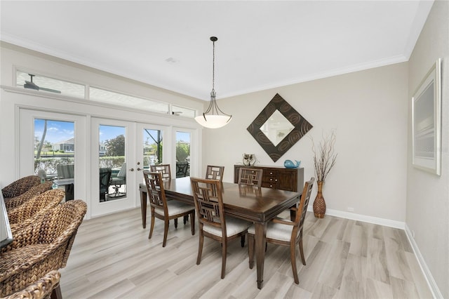 dining space featuring french doors, light hardwood / wood-style flooring, ceiling fan, and crown molding