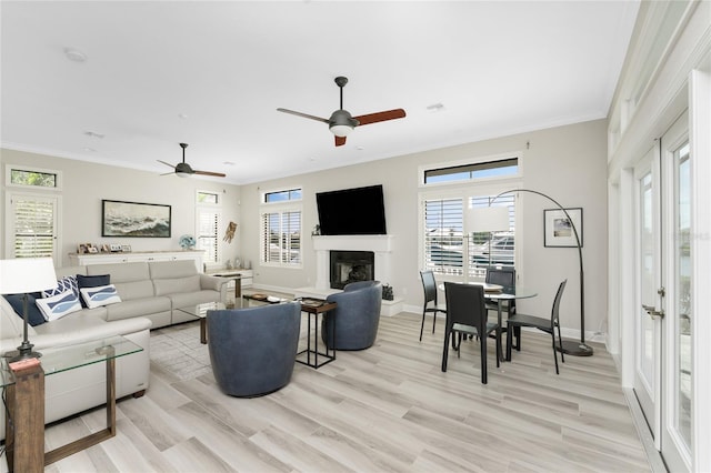 living room featuring ornamental molding, ceiling fan, and light hardwood / wood-style flooring