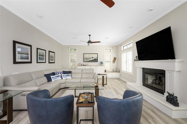 living room featuring ornamental molding, light hardwood / wood-style flooring, and ceiling fan