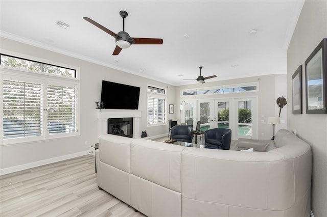 1945 Jamaica Way, Punta Gorda, FL 33950 - living room with ceiling fan, french doors, a glass covered fireplace, crown molding, and light wood-style flooring
