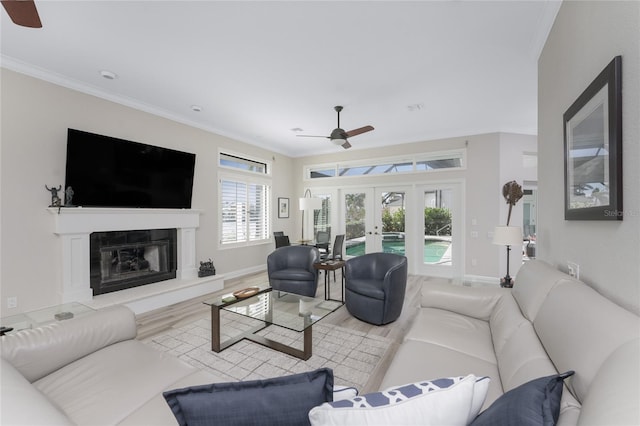 living room with french doors, light wood-type flooring, ornamental molding, and ceiling fan