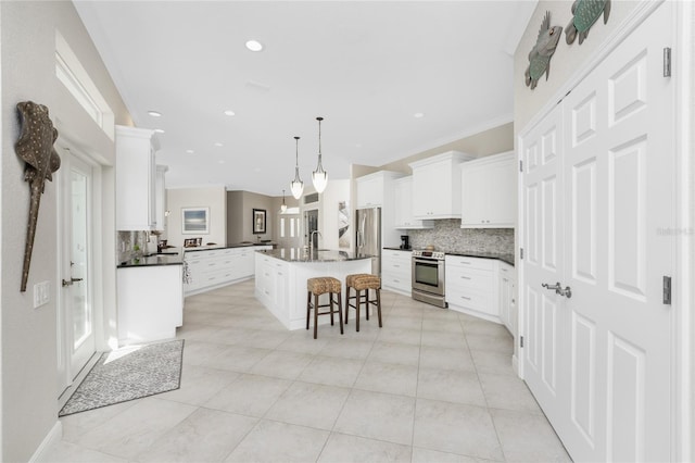 1945 Jamaica Way, Punta Gorda, FL 33950 - kitchen featuring stainless steel appliances, decorative backsplash, an island with sink, a kitchen breakfast bar, and recessed lighting