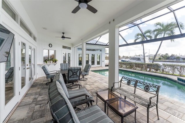 view of patio / terrace with glass enclosure, french doors, a water view, and ceiling fan