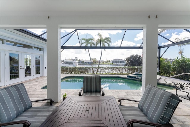 view of swimming pool featuring glass enclosure, french doors, an in ground hot tub, a patio area, and a water view