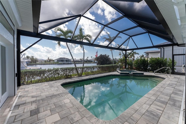 view of pool featuring a water view, glass enclosure, a patio, and an in ground hot tub