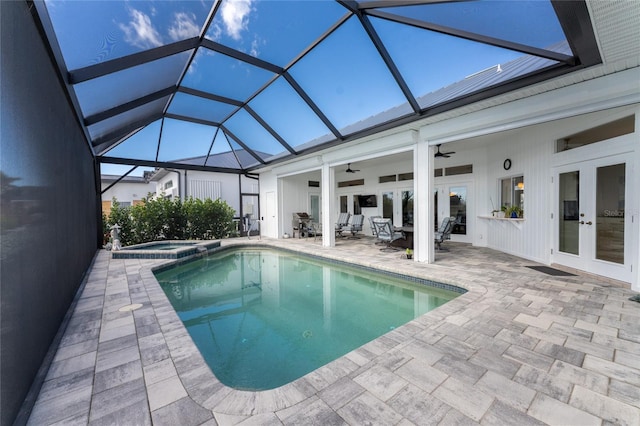 view of swimming pool featuring glass enclosure, french doors, an in ground hot tub, a patio, and ceiling fan