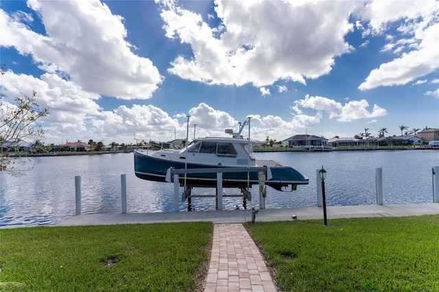 view of dock with a yard and a water view