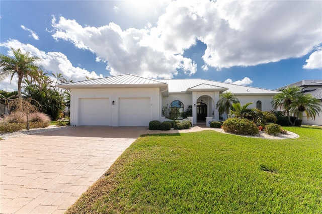 1945 Jamaica Way, Punta Gorda, FL 33950 - view of front facade featuring decorative driveway, a garage, a front yard, a metal roof, and stucco siding