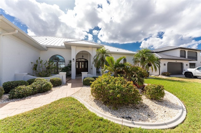 1945 Jamaica Way, Punta Gorda, FL 33950 - view of front of property with stucco siding, a standing seam roof, a garage, a front yard, and a metal roof