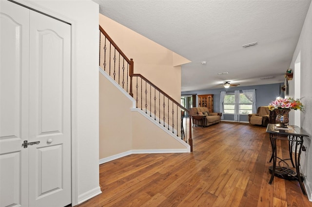 foyer featuring hardwood / wood-style floors, a textured ceiling, and ceiling fan