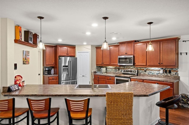 10122 Winding River Rd, Punta Gorda, FL 33950 - kitchen featuring appliances with stainless steel finishes, a sink, a breakfast bar area, a peninsula, and decorative backsplash