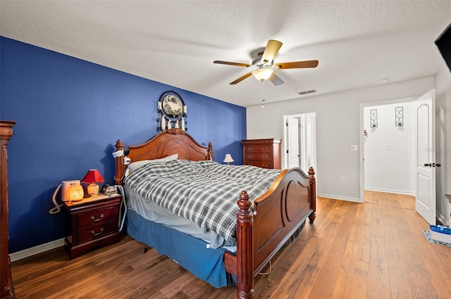 bedroom featuring ceiling fan, a textured ceiling, and wood-type flooring