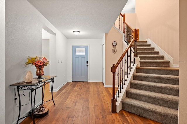 10122 Winding River Rd, Punta Gorda, FL 33950 - foyer with stairs, baseboards, hardwood / wood-style floors, and a textured ceiling
