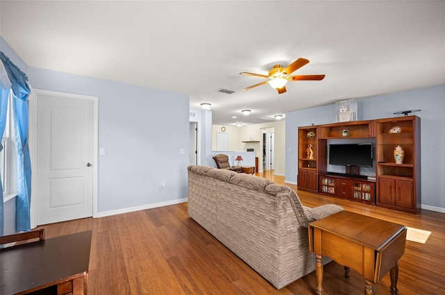 living room with dark wood-type flooring and ceiling fan