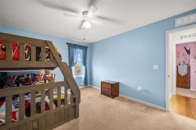 carpeted bedroom with a textured ceiling and ceiling fan