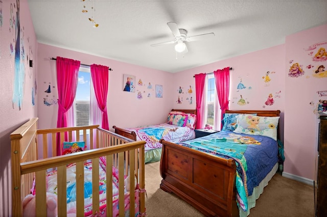 carpeted bedroom featuring ceiling fan and a textured ceiling