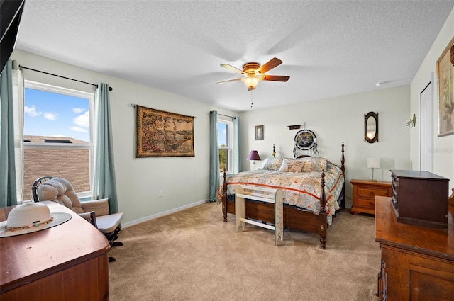 bedroom featuring ceiling fan, a textured ceiling, and light carpet