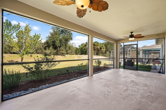 unfurnished sunroom featuring ceiling fan and a healthy amount of sunlight