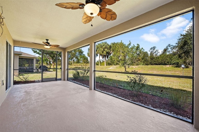 unfurnished sunroom with ceiling fan