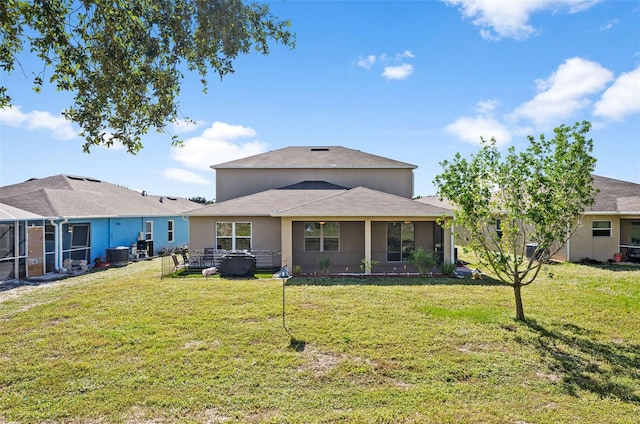 back of house featuring central air condition unit, a sunroom, and a lawn