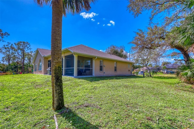 back of house featuring a yard and a sunroom