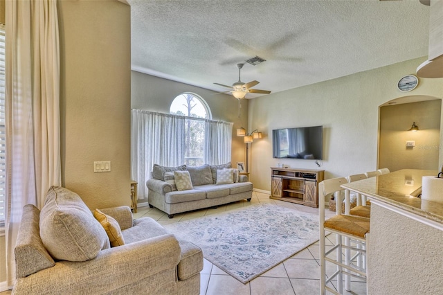 tiled living room featuring ceiling fan and a textured ceiling