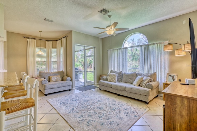 tiled living room featuring a textured ceiling and ceiling fan