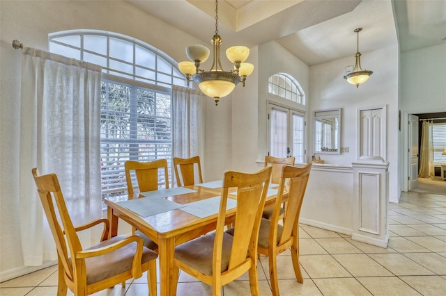 tiled dining room featuring a high ceiling and a notable chandelier