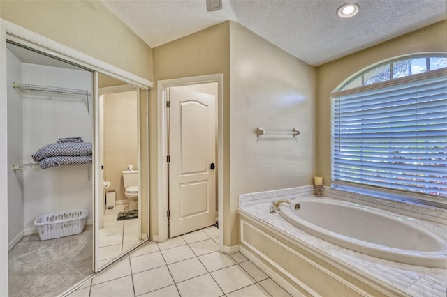 bathroom featuring tile patterned floors, a textured ceiling, toilet, and lofted ceiling