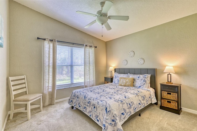 bedroom featuring light carpet, a textured ceiling, vaulted ceiling, and ceiling fan