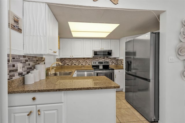 kitchen with sink, white cabinetry, decorative backsplash, and stainless steel appliances