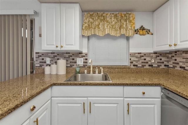 kitchen with stone countertops, backsplash, sink, stainless steel dishwasher, and white cabinets