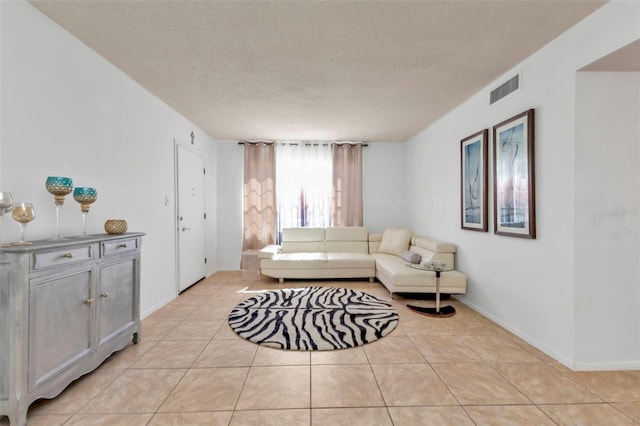 living room featuring a textured ceiling and light tile patterned floors