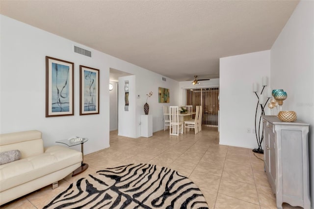 tiled living room featuring a textured ceiling