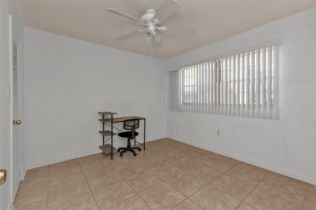 unfurnished room with ceiling fan and light tile patterned floors