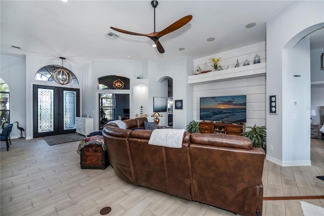 living room featuring french doors, light wood-type flooring, and plenty of natural light