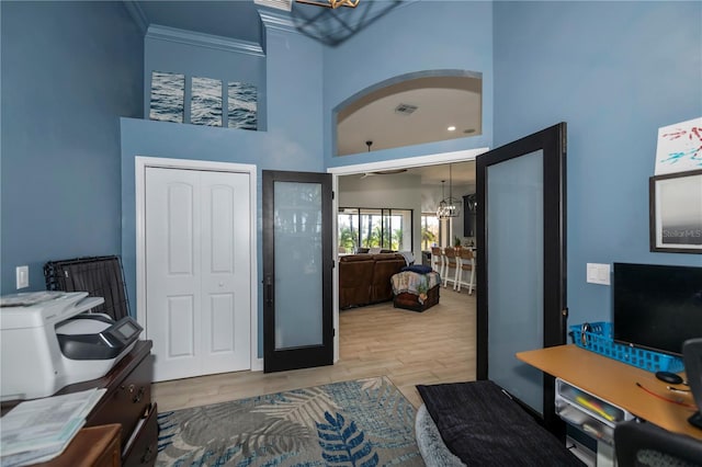 bedroom featuring light wood-type flooring, a high ceiling, crown molding, and a closet