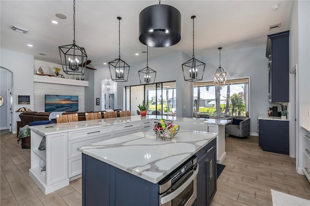 kitchen with a spacious island, white cabinetry, and pendant lighting