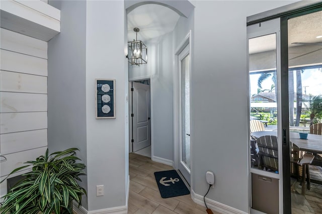 corridor with a notable chandelier and light hardwood / wood-style floors