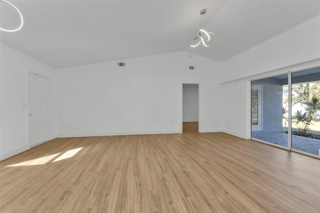 spare room with vaulted ceiling and light hardwood / wood-style floors