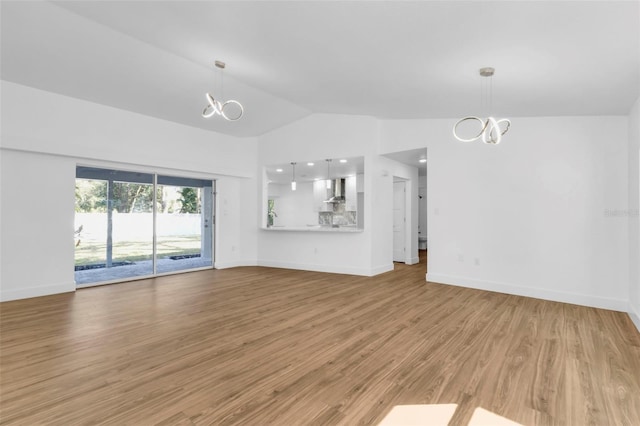 unfurnished living room featuring high vaulted ceiling, a chandelier, and light hardwood / wood-style floors