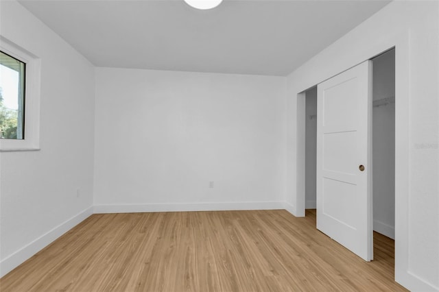 unfurnished bedroom featuring a closet and light wood-type flooring