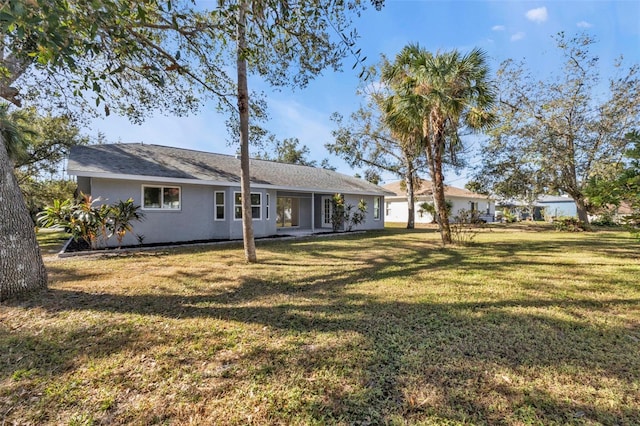 rear view of house featuring a yard