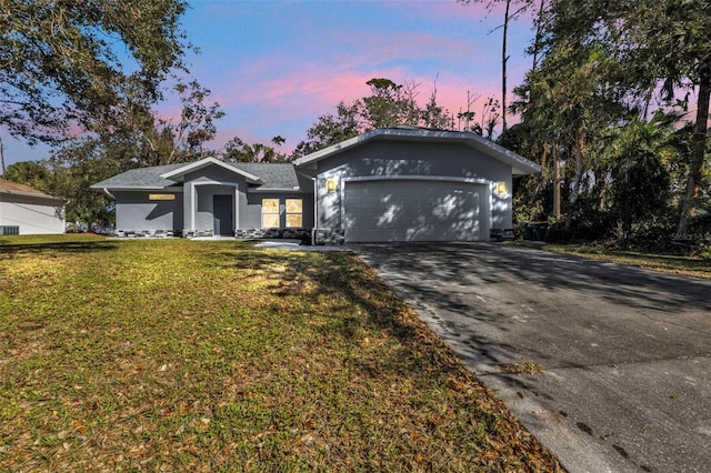 ranch-style house featuring a garage and a lawn