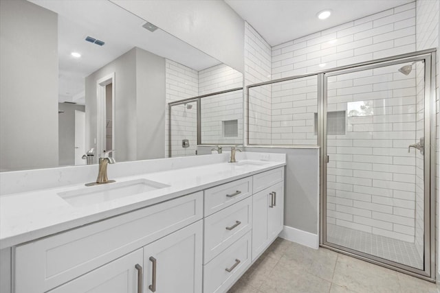 bathroom with tile patterned floors, vanity, and a shower with door